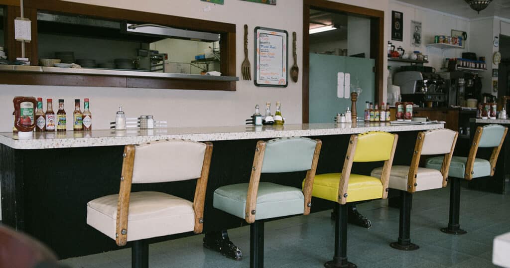 A diner with a long table and chairs.