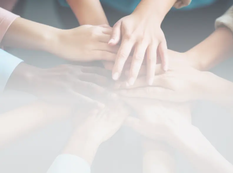 A group of hands stacked together, symbolizing teamwork, unity, and collaboration.