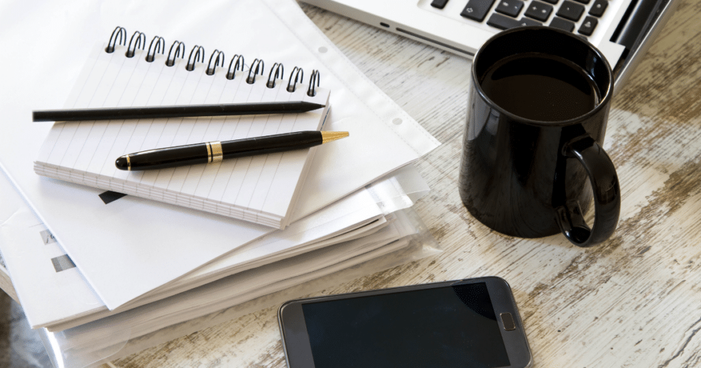 Papers on a desk with a coffee cup, representing a job search.